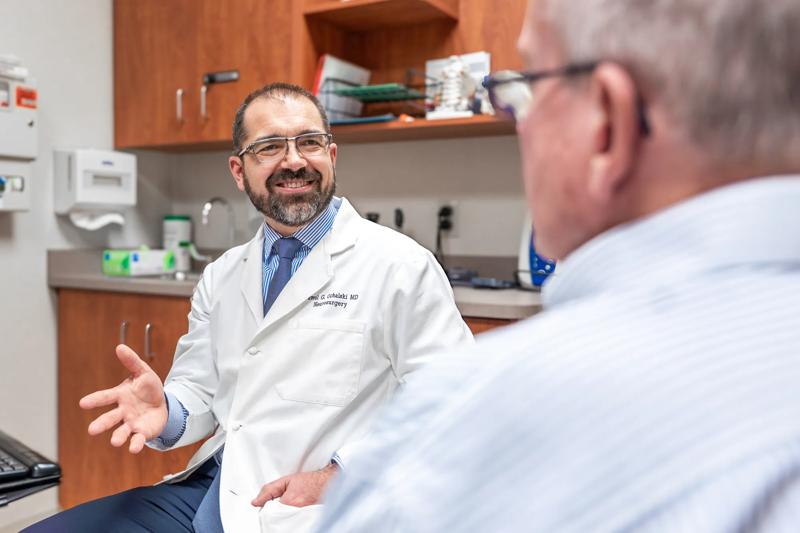 Photos of Dr. Pawel Ochalski with patient Steve reviewing scans of recent neurosurgery. For use in Macroscope Magazine #3.