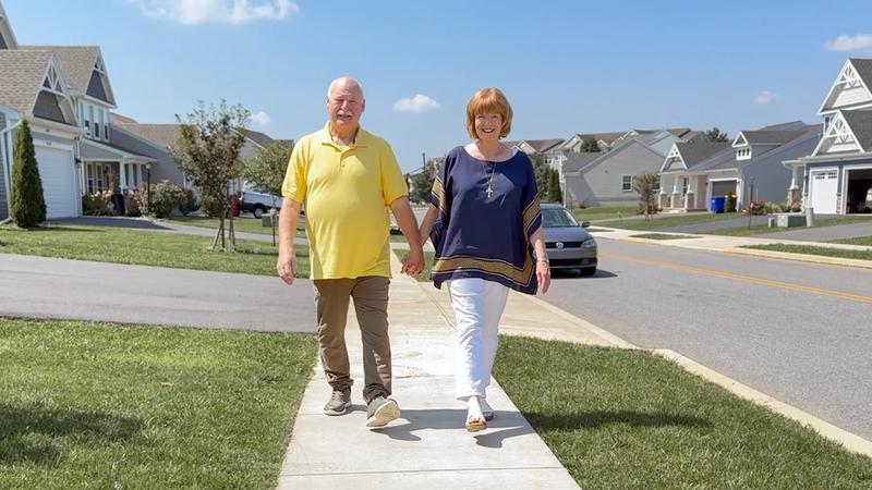 Randy and his wife walking together on a neighborhood sidewalk