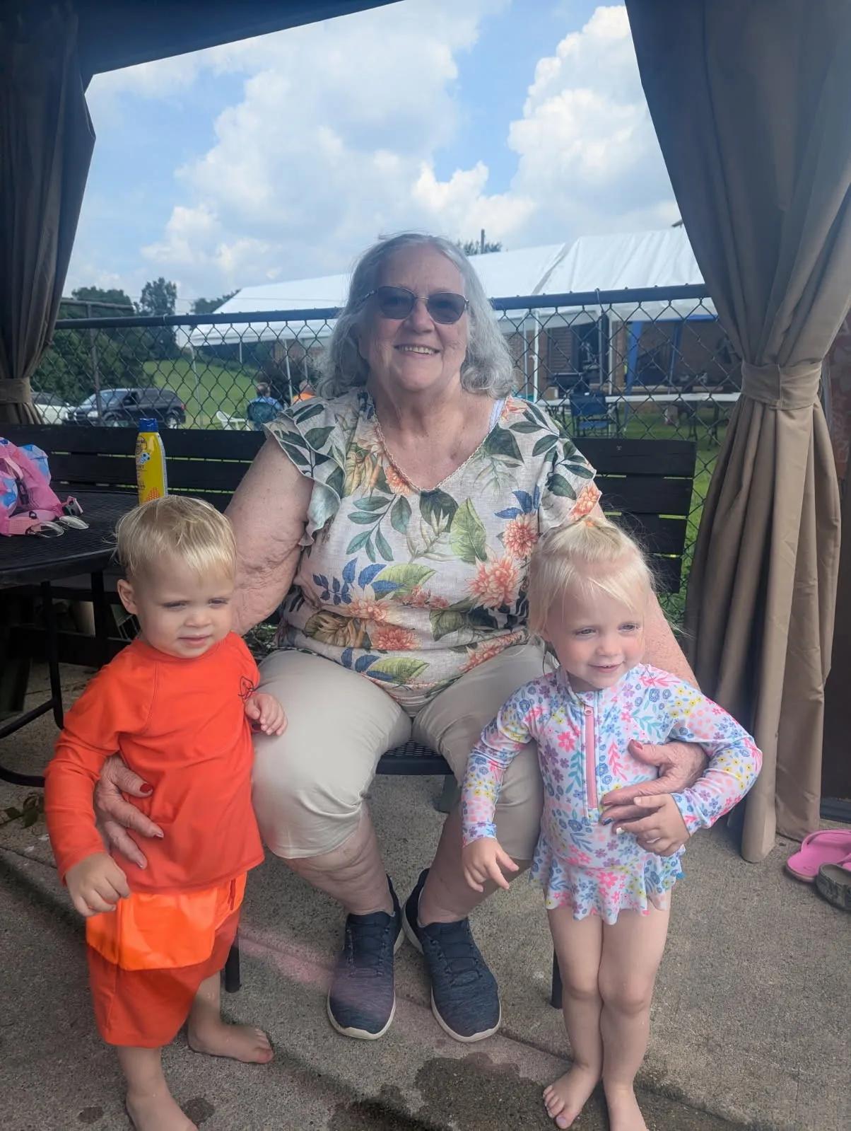 Bonnie Hemming in 2025 (the sitting pose) side by side comparison to her in 2026 (standing in Tennessee) following 50+ pounds of weightloss.
Bonnie Hemming with grandkids George and Emma in July 2026 at their annual family gathering in western Pennsylvania.