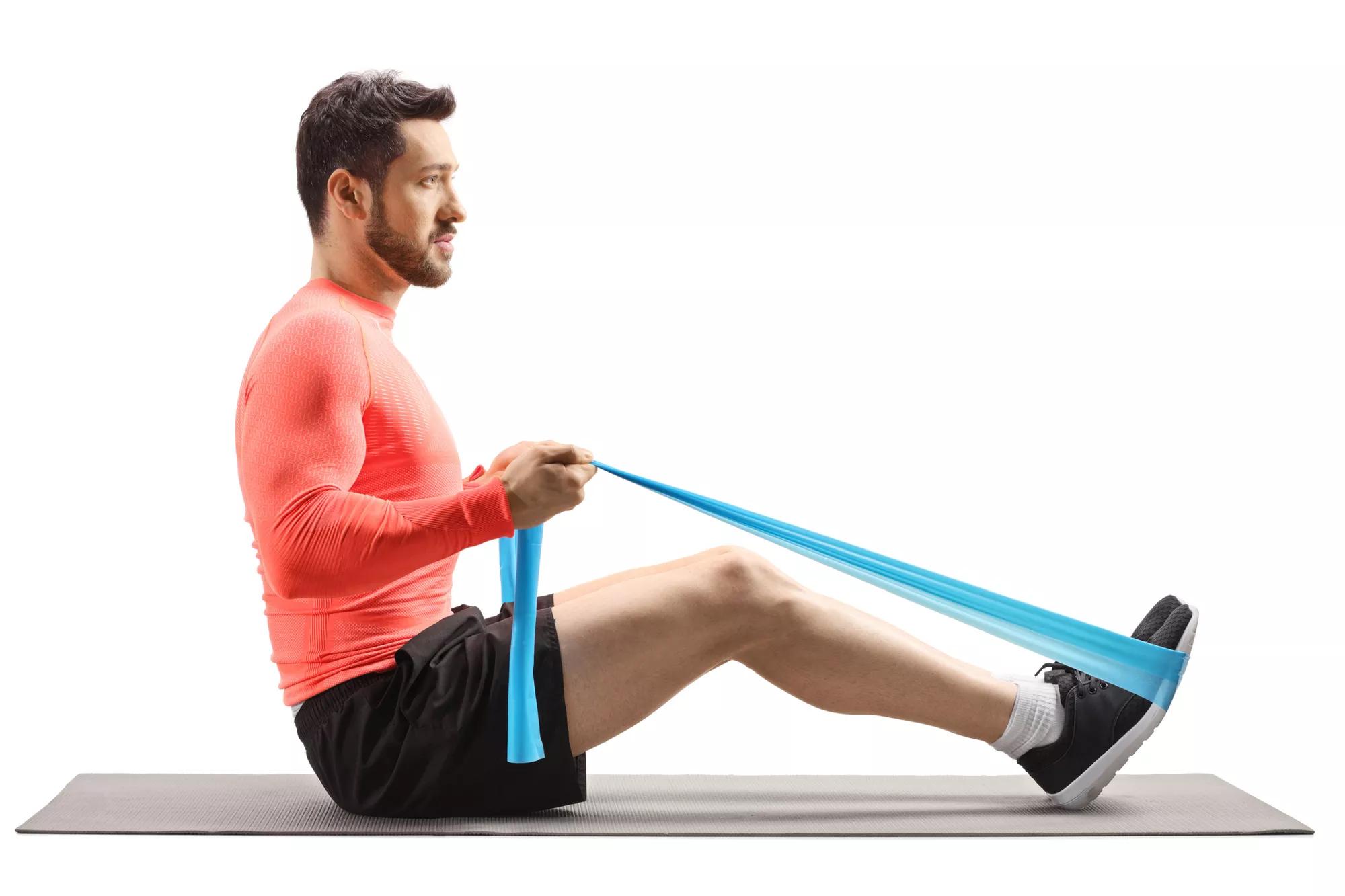 Fit man exercising with an elastic band isolated on white background